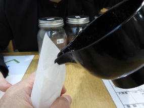 =調合した香りを紙の袋に入れる様子