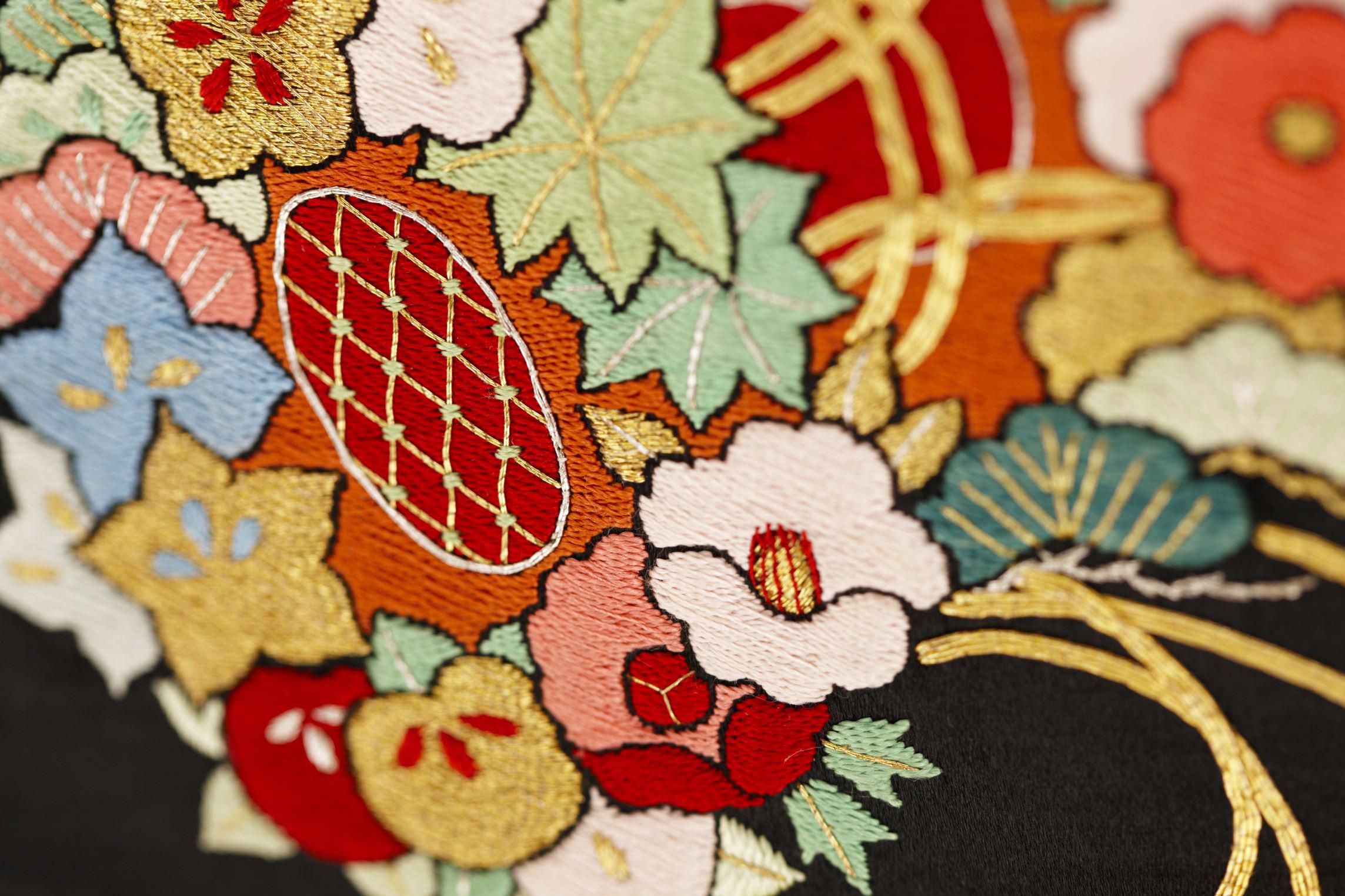 黒繻子の名古屋帯に刺繍されたのは、花で飾った「鼓」