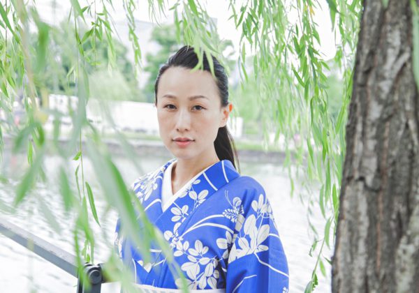 青色の鮮やかな萩柄小紋を見にまとう伊藤さん