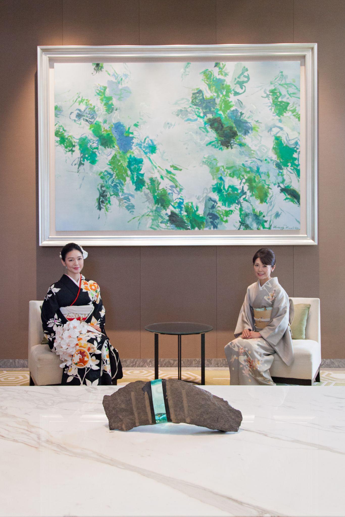 レセプションロビーに飾られた菅原健彦氏による絵画の前にて