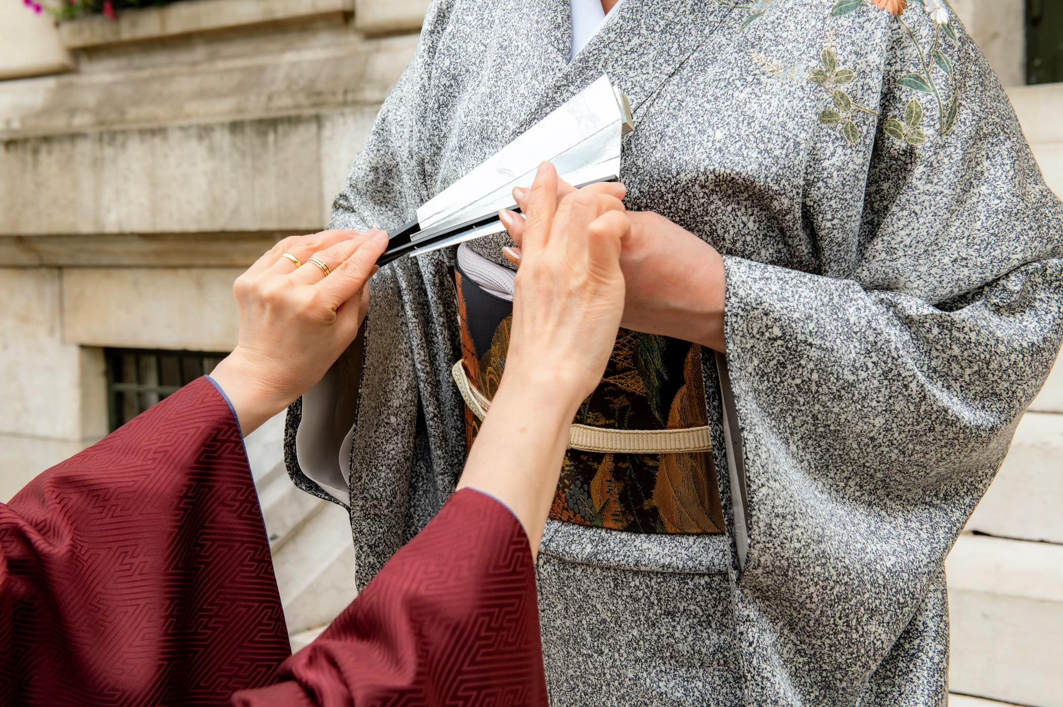胸に引き寄せた扇子の持ち方