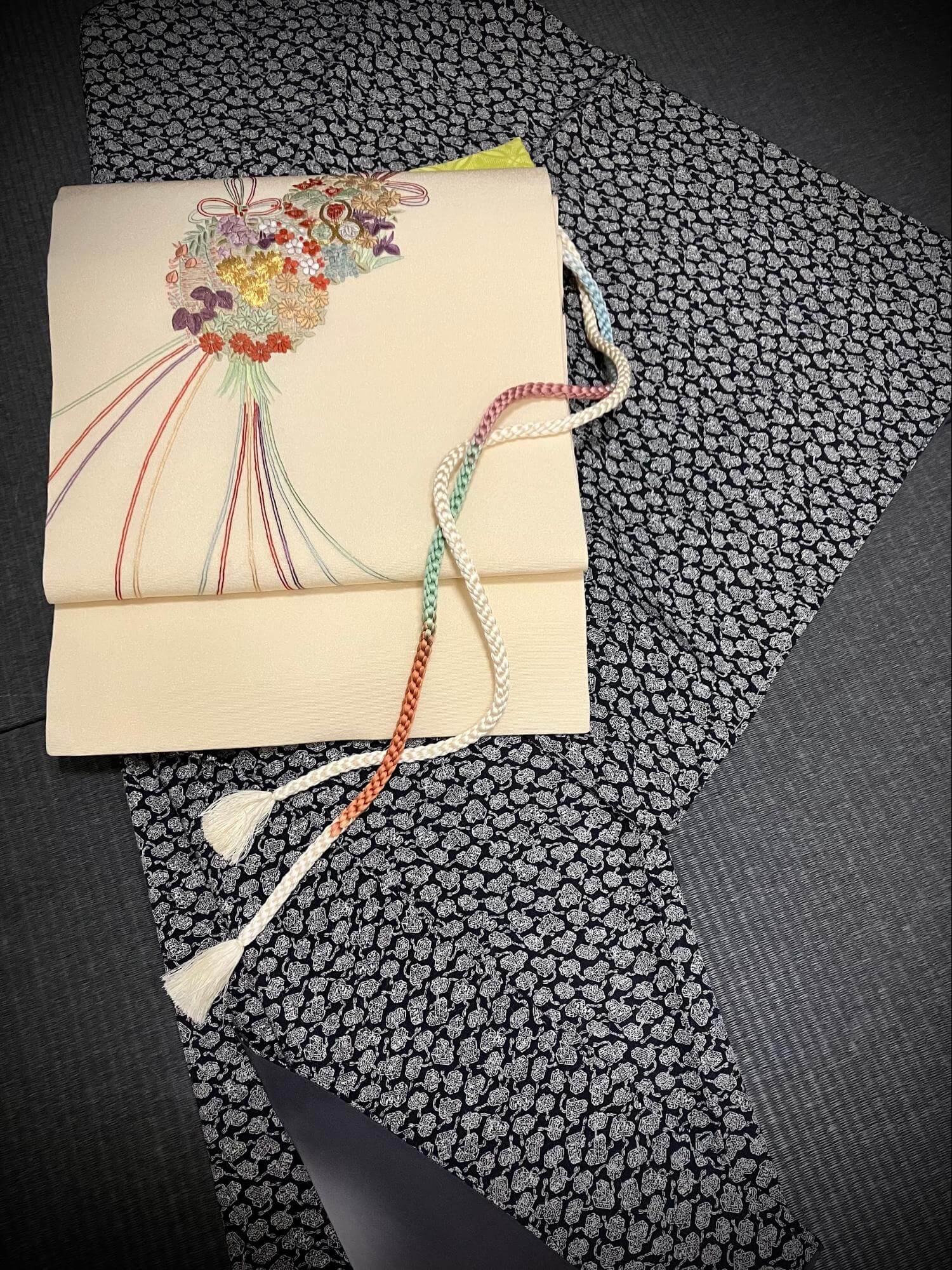遊び心のある小紋に花薬玉の手刺繍が施された名古屋帯を合わせて。