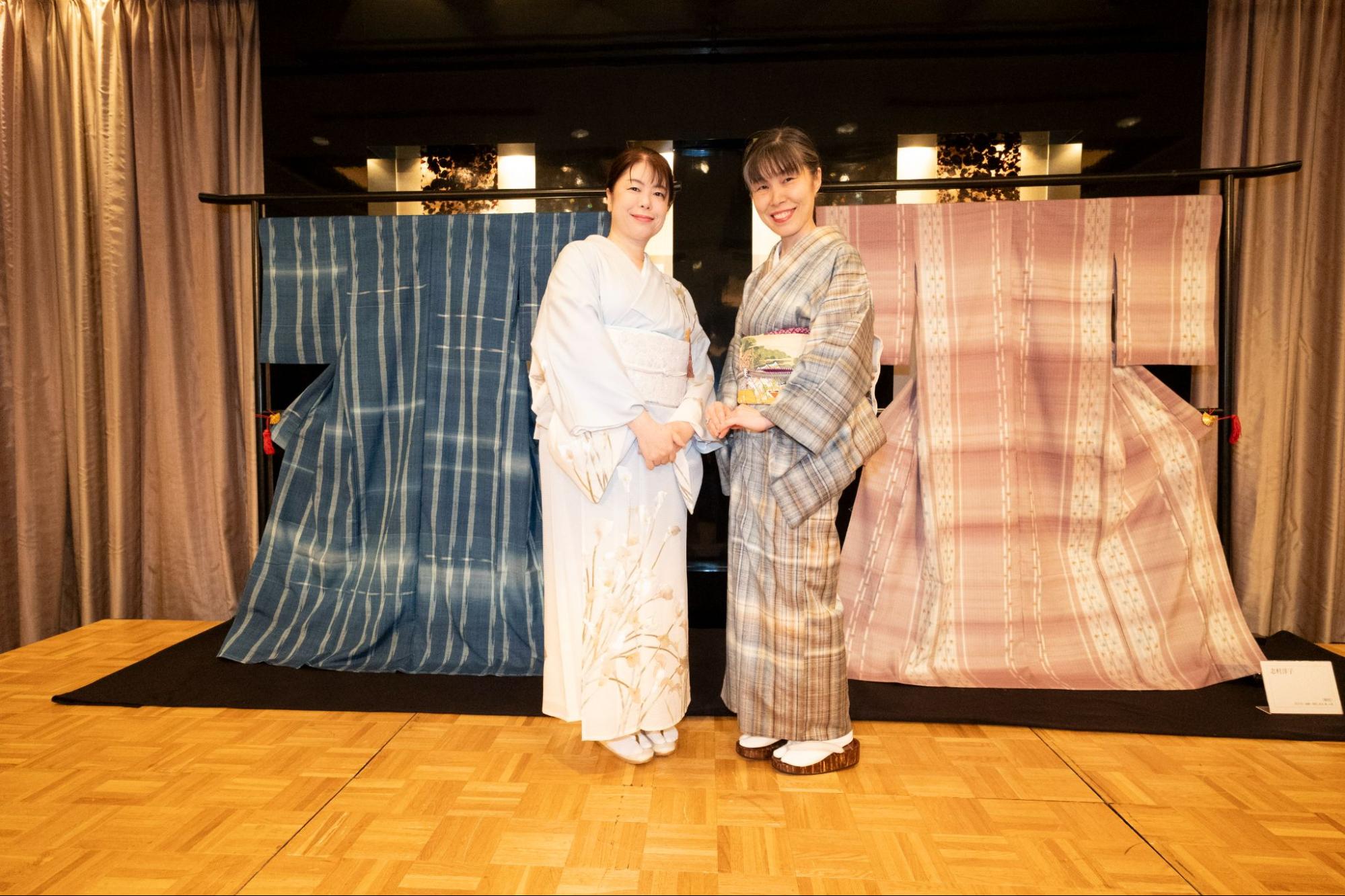 志村ふくみさんの着物をバックに写真を撮る女性2名