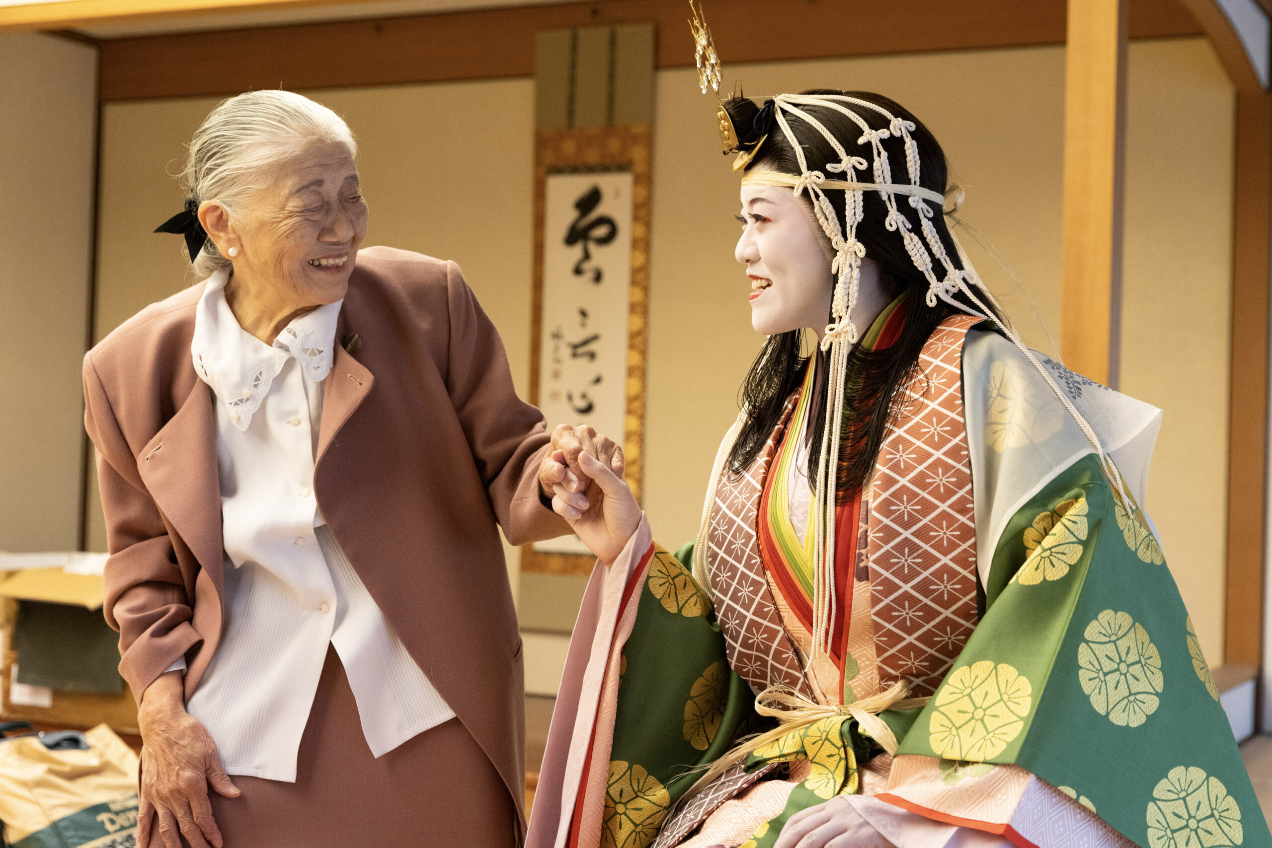 祖母と手を取り合い、カメラに向かって笑顔を見せる石﨑さん
