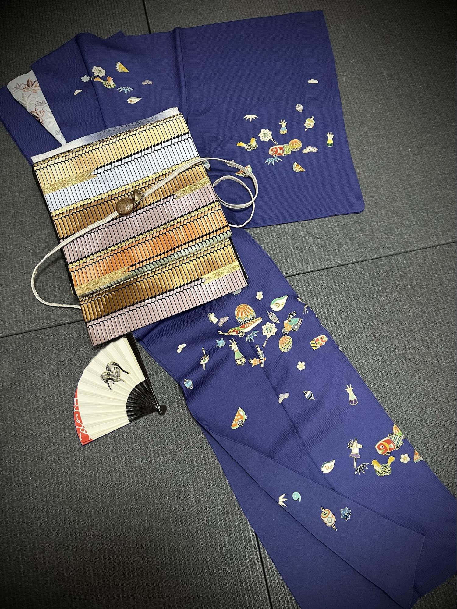 瑠璃紺の地に松竹梅とともに玩具が散りばめられた訪問着